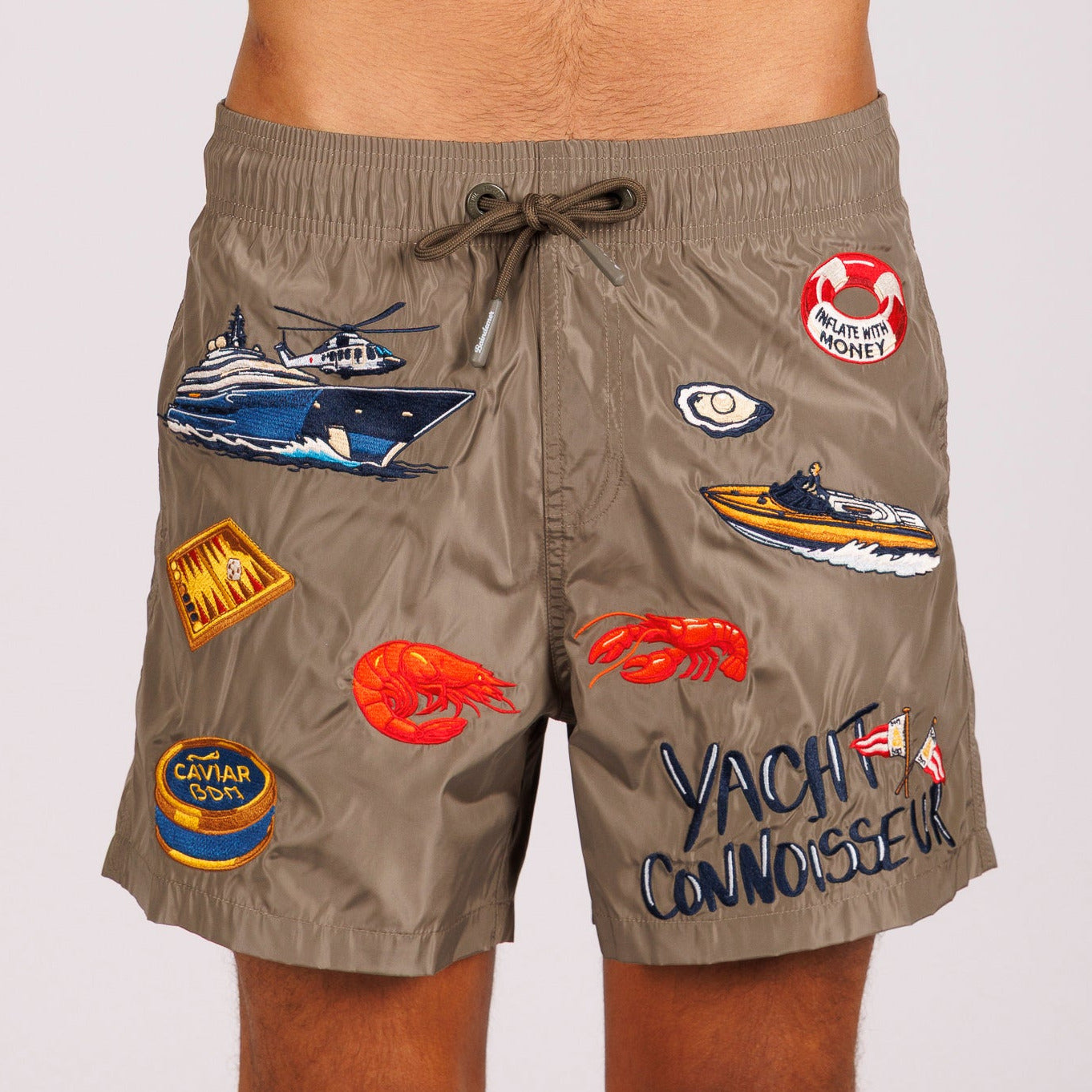 Khaki swim shorts front view with illustrated graphic and “Yacht connoisseur” text