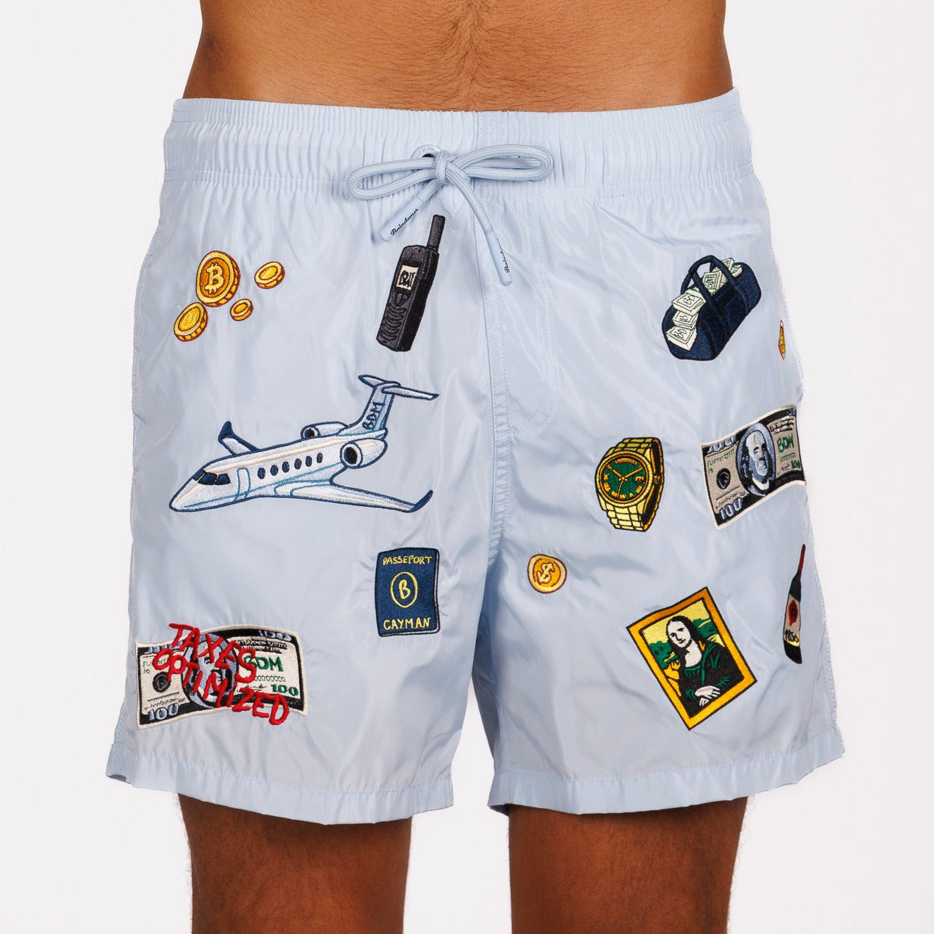 Light blue swim shorts front view with illustrated graphic and “Taxes optimized” text