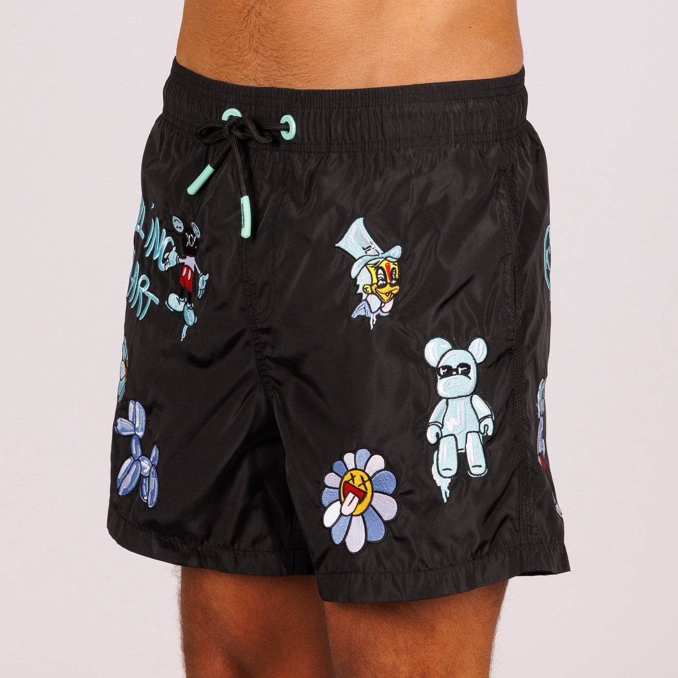 Black swim shorts side view with illustrated graphic