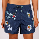 Navy blue swim shorts front view with illustrated graphic and “Falling in art” text