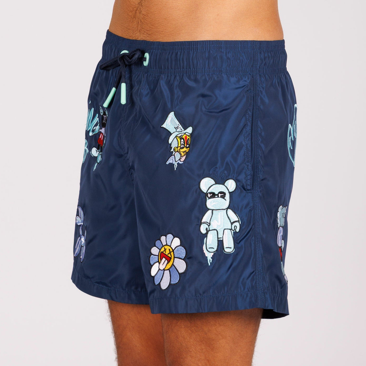 Navy blue swim shorts side view with illustrated graphic