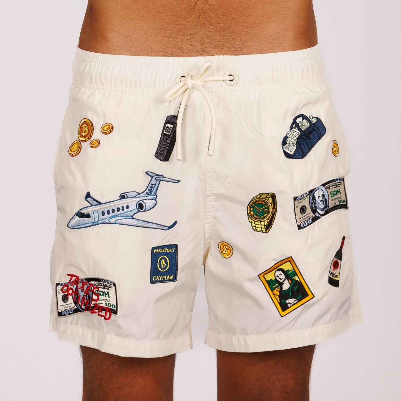 Off-white swim shorts front view with illustrated graphic and “Taxes optimized” text