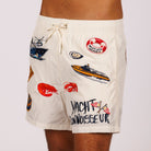Off-white swim shorts side view with illustrated graphic and “Yacht connoisseur” text