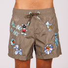 Khaki swim shorts front view with illustrated graphic and “Falling in art” text