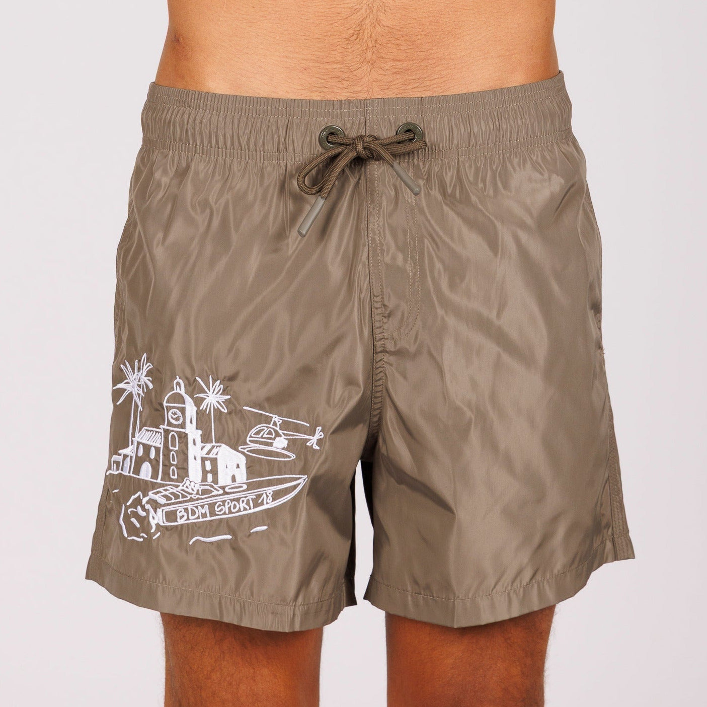 Khaki swim shorts front view with illustrated graphic and “BDM Sport 18” text