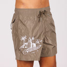 Khaki swim shorts side view with illustrated graphic and “BDM Sport 18” text