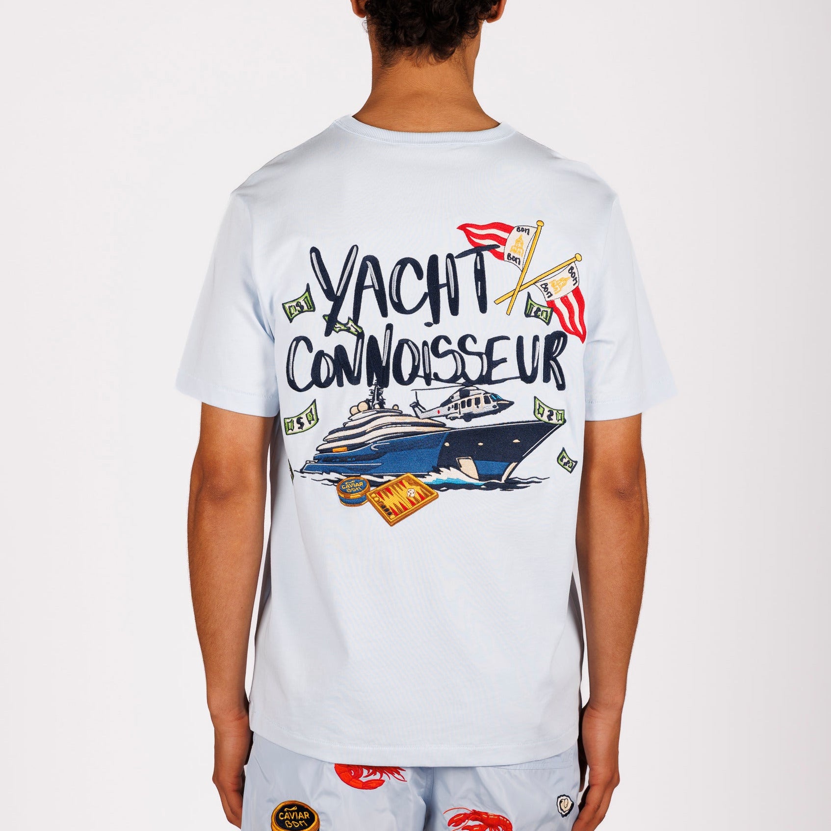 Light blue T-shirt back view with illustrated graphic and “Yacht connoisseur” text