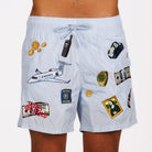 Light blue swim shorts front view with illustrated graphic and “Taxes optimized” text
