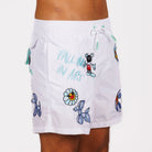 White swim shorts side view with illustrated graphic and “Falling in art” text