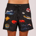 Black swim shorts front view with illustrated graphic and “Yacht connoisseur” text