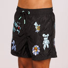 Black swim shorts side view with illustrated graphic